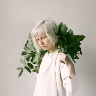 photography-of-a-woman-holding-green-leaves-1071162